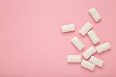 Chewing gum pieces on pink background. Space for text. Top view