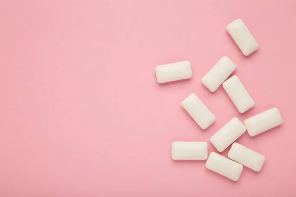 Chewing gum pieces on pink background. Space for text. Top view