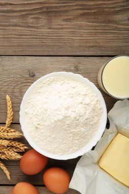 Ingredients for baking or cooking, egg flour, rolling pin butter, milk on a grey wooden background Cookie pie or cake recipe. Vertical photo,