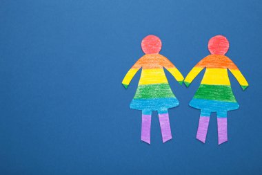Kağıttan kesilen ve LGBT renkleriyle boyanmış kağıt kadınlar. LGBT kavramı. Mesaj için yer var. Üst görünüm.