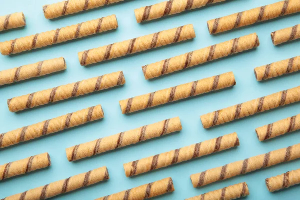 Wafer roll sticks cream rolls on blue background. Minimalism. Top view