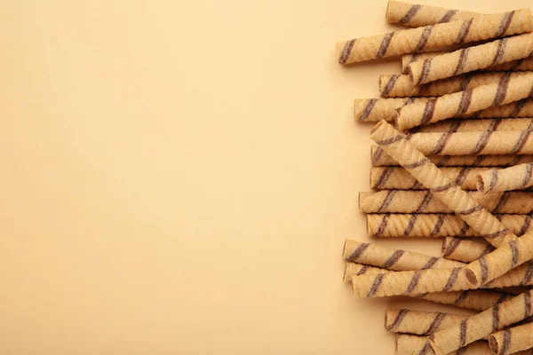 Wafer roll sticks cream rolls on beige background. Space for text. Top view