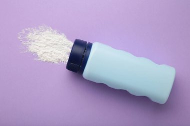 Baby powder on purple background. Baby cosmetics. Top view