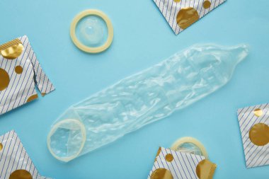 Mavi arka planda kullanılan prezervatif. Güvenli seks konsepti. Üst görünüm
