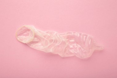 Condom used on a pink background. Safe sex concept. Top view