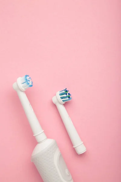 ピンクを基調としたモダンな電動歯ブラシ 毎日の口腔ケアのための制御ツール 垂直写真 — ストック写真