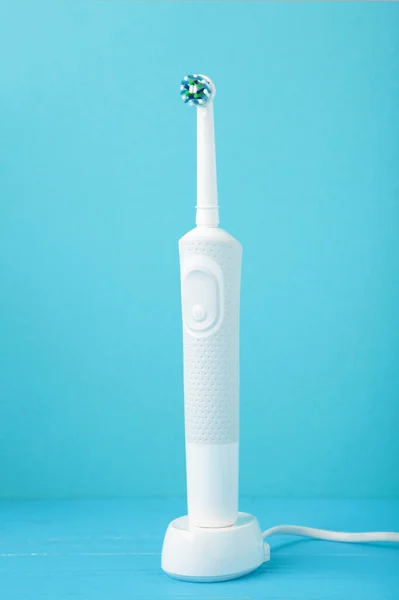 ブルーを基調に充電器付きのモダンな電動歯ブラシ トップ表示 — ストック写真