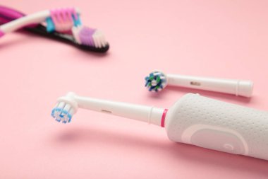 Pembe arka planda elektrikli ve manuel diş fırçası. Üst görünüm