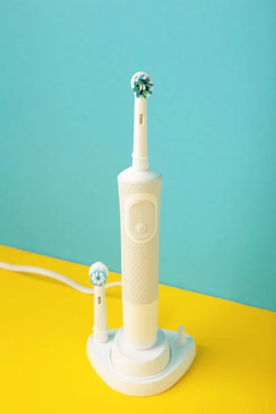カラフルな背景に充電器と現代の電動歯ブラシ トップ表示 — ストック写真
