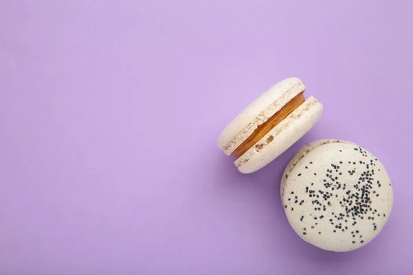 Cake macaron or macaroon on purple background. Space for text. Top view