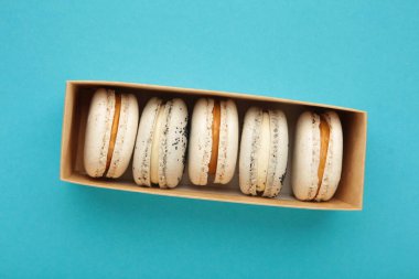 Pastel badem kurabiyeleri mavi arka planda kutuda. Üst görünüm