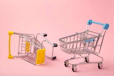 Pembe arka planda mini alışveriş arabası. Metin için boşluk