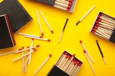 Sarı arka planda yanmış kibritlerle dolu bir kutu. Üst görünüm