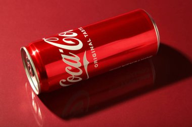Mykolaiv, Ukrayna - 2 Mayıs 2023: Kırmızı arka planda gölgesi olan Coca Cola kutusu. Üst görünüm.