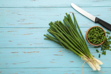 Mavi ahşap arka planda yeşil soğan kes. Mesaj için yer var. Üst görünüm