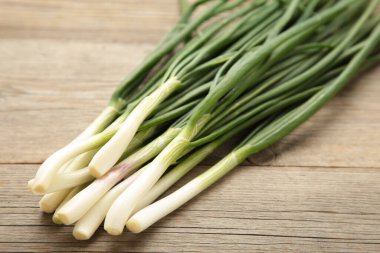 Gri ahşap zemin üzerinde yeşil soğan. Üst görünüm