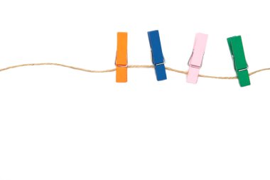 Beyaz arka planda izole edilmiş bir halatın üzerindeki renkli ahşap mandallar. Tasarım elemanları. Makro. Üst görünüm