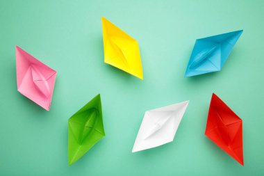 Arka planda renkli kağıt gemileri, liderlik ve iş yarışması konseptleri. Üst görünüm