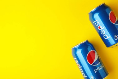 Mykolaiv, Ukrayna - 2 Mayıs 2023: Pepsi içeceği sarı arka planda. Pepsi, PepsiCo tarafından üretilen karbonatlı meşrubattır. Üst görünüm