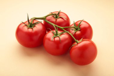 Bej arka planda bir demet domatesli düz kompozisyon. Mesaj için yer var. Üst görünüm