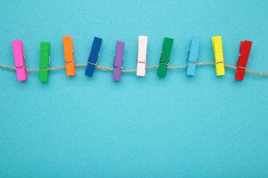Mavi arka planda renkli ahşap mandallar. Tasarım elemanları. Makro. Üst görünüm