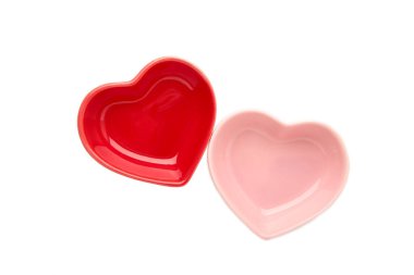Beyaz arka planda izole edilmiş kırmızı ve pembe kalp şeklinde kaseler. Üst görünüm