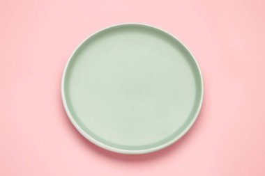 Pembe arka planda boş seramik yuvarlak plaka ve kırpma yolu. Üst görünüm