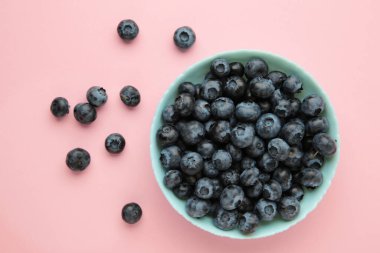 Pembe arka planda taze yaban mersini kasesi. Mesaj için yer var. Sağlıklı beslenme kavramı. Üst görünüm
