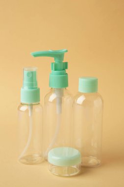 Bej arka planda boş seyahat kozmetik şişeleri. Tatil veya seyahat için minimalist vücut bakımı ürünleri.