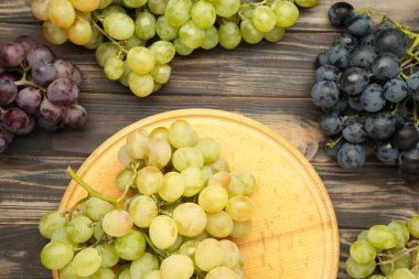 Kahverengi ahşap arka planda çeşitli üzümler. Üst görünüm