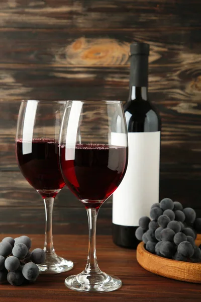 Weinflasche Und Weinglas Mit Trauben Auf Braunem Holzgrund Vertikales Foto — Stockfoto