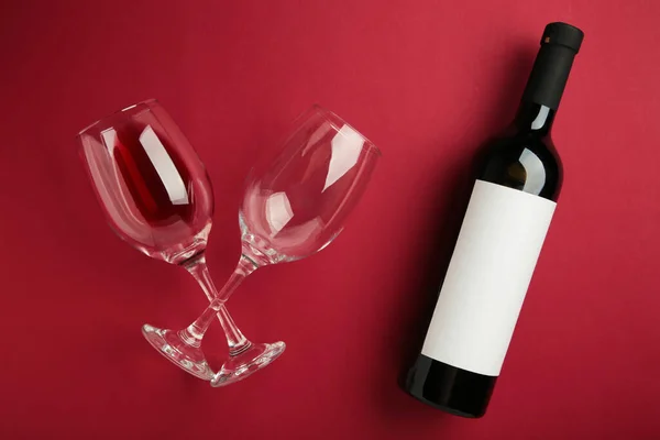 Flache Liegende Rotweinflasche Mit Gläsern Zur Verkostung Auf Dunkelrotem Hintergrund — Stockfoto