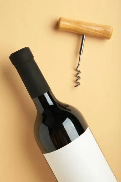 ベージュのバックグラウンドに赤ワインとコルクスクリューをボトル 縦の写真 トップビュー — ストック写真