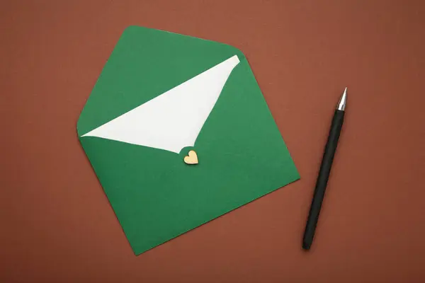 Groene Envelop Pen Bruine Achtergrond Bovenaanzicht — Stockfoto