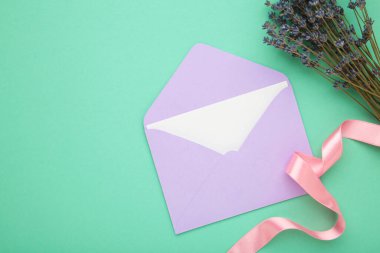 Zarflı maket, lavanta ve nane arkaplanlı kurdele. Üst görünüm.