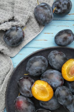 Mavi arka planda koyu tabakta taze erikler. Dikey fotoğraf. Üst görünüm