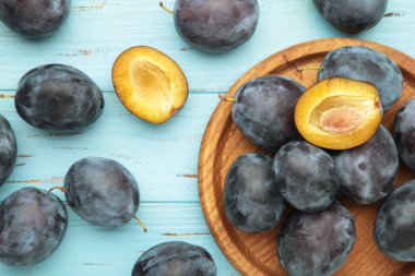 Taze erikler ahşap tabakta mavi ahşap arka planda. Üst görünüm