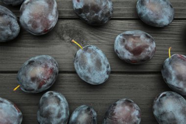 Siyah ahşap arka planda olgun erikler. Sonbahar hasadı. Üst görünüm