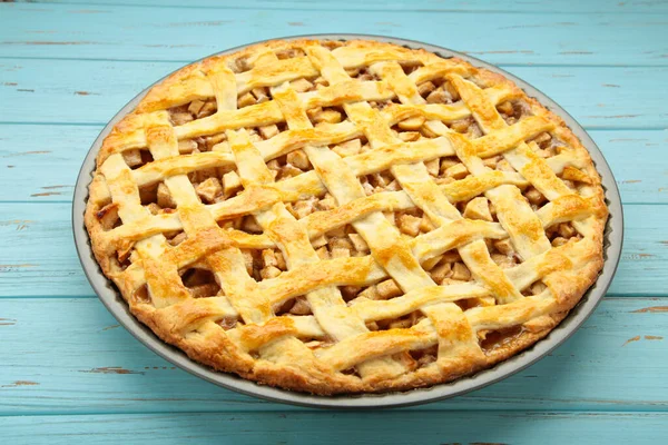 Homemade sweet american apple pie with sugar and cinnamon. Tart on blue wooden background. Top view
