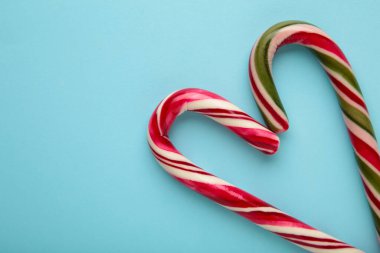 Mavi arka planda güzel bir Noel şekeri kalbi. Üst görünüm