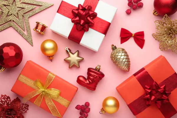 Christmas composition. Gifts, red and gold decorations on pink background. New year concept. Top view