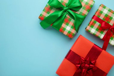 Mavi arka planda kurdeleli yeşil bir hediye. Noel konsepti. Metin için boşluk