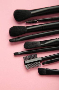 Profesyonel kadın makyaj fırçası ve pembe arka planda kirpik fırçası. Kozmetik konsepti, makyaj konsepti. Üst görünüm