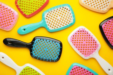 Sarı arka planda saç fırçaları. Düz yatıyordu. Üst görünüm