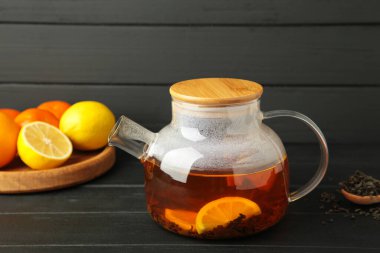 Siyah arka planda cam çaydanlıkta limonlu siyah çay. Sağlıklı içki konsepti. Üst görünüm