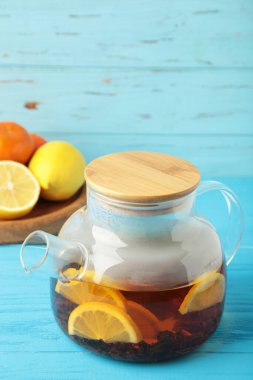 Mavi arka planda cam çaydanlıkta limonlu siyah çay. Sağlıklı içki konsepti. Üst görünüm