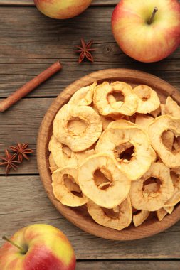Tarçınlı kurutulmuş elma cipsi ve taze elmalı yıldız anason. Gri ahşap arka planda kesilmiş ev yapımı organik elma. Üst görünüm