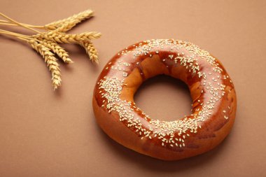 Kahverengi arka planda tohumu olan taze ekmek simidi. Üst görünüm