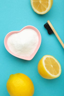 Limonlu diş fırçası ve mavi arka planda kabartma tozu. Dikey fotoğraf. Üst görünüm