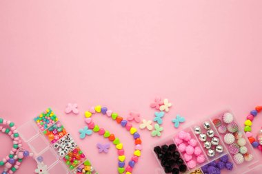 Mor arka planda çocuk için el yapımı mücevherler yapmak için boncuklu bir kutu. Bileklik. El yapımı aksesuarlar. Üst görünüm